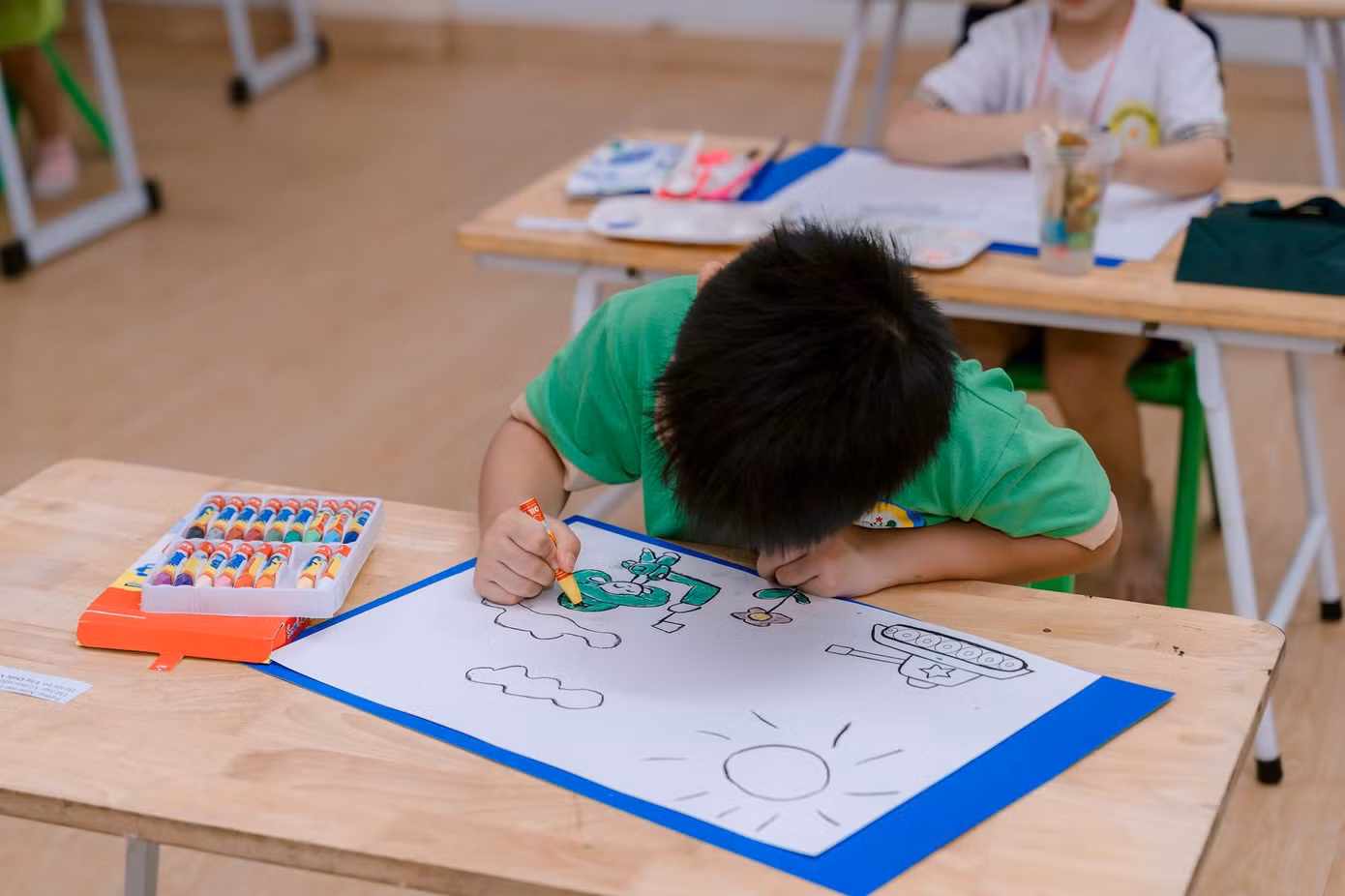 Một "họa sĩ nhí" chăm chú tô màu cho bức tranh của mình.