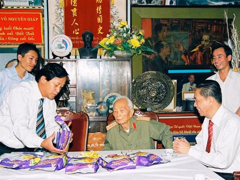 Ông Nguyễn Lâm Viên (ngồi, bên phải) và ông Nguyễn Lân Hùng đang giới thiệu với Đại tướng Võ Nguyên Giáp về sản phẩm từ cây mít