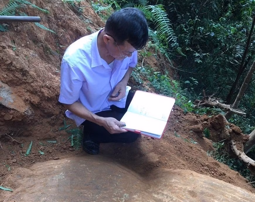 Cán bộ Bảo tàng tỉnh Yên Bái nghiên cứu tổng hợp về những khối đá khắc cổ mới được phát hiện tại thôn Háng Chua Say, xã Chế Cu Nha, huyện Mù Cang Chải. (Ảnh: TTXVN phát)