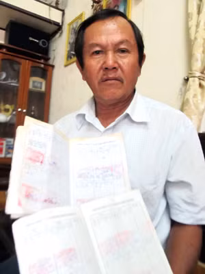 Ông Hồ Văn Tình với 2 cuốn sổ nhật trình năm 2012 của đôi tàu có xác nhận của các trạm biên phòng ảnh: Nam Cường