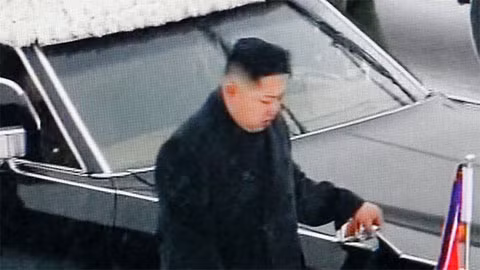 Đại tướng Kim Jong Un trong bộ đồ đen đi bên linh cữu cha. Ảnh: AP