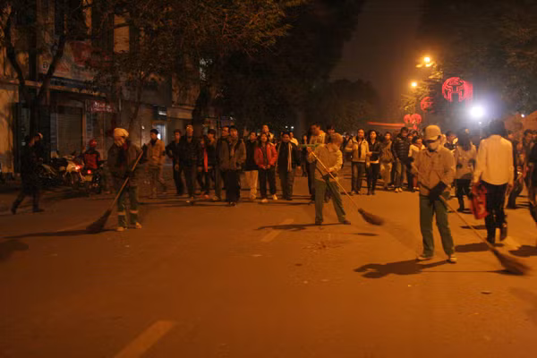 Các công nhân dọn vệ sinh đường Đinh Tiên Hoàng - nơi trưng bày phố hoa đêm 1-1-2012