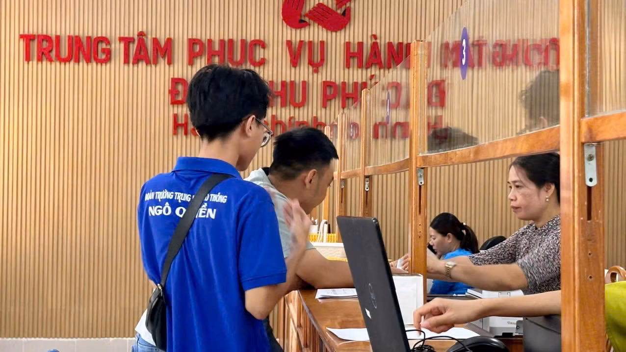 Đoàn viên Quốc Bình đang giúp người dân đăng ký giấy tờ đất, giấy phép kinh doanh, giấy khai sinh và kí xác nhận một số giấy tờ khác.