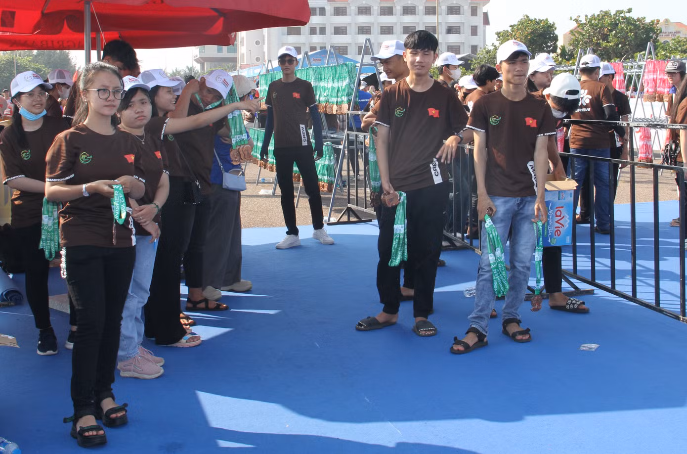 Các tình nguyện viên làm nhiệm vụ trao huy chương tặng vận động viên tại cổng về đích.