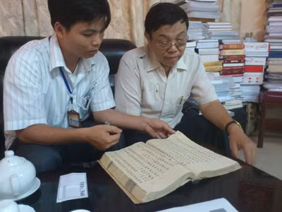 PGS TS Trịnh Khắc Mạnh (phải) và một nghiên cứu viên của Viện Nghiên cứu Hán Nôm đang xem lại trước tác của Dương Khuê. Ảnh: Hà Anh
