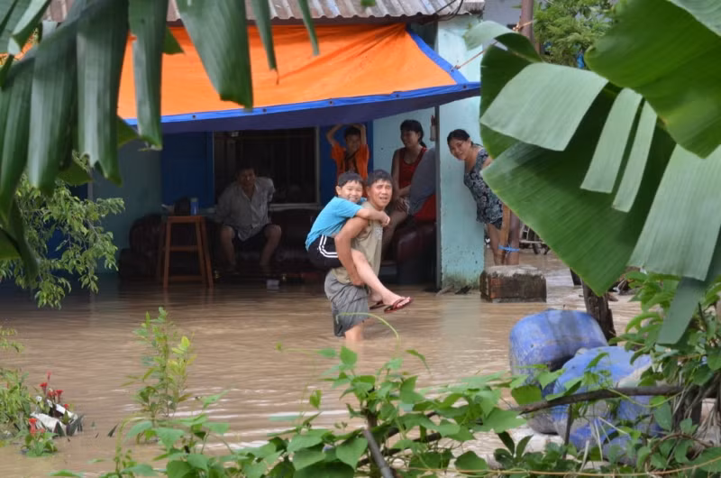 Lũ bao vây, cả nhà trông chờ đoàn cứu trợ. Ảnh Việt Hương