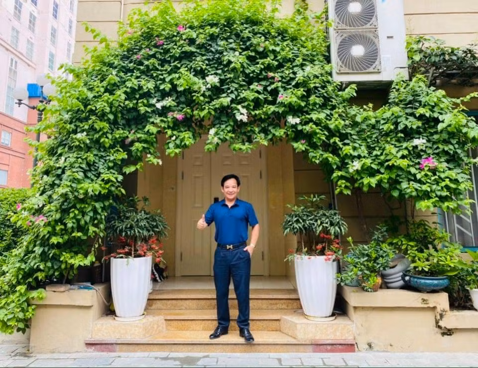 Quang Tèo đứng trước cửa nhà rợp cây xanh Quang Tèo đứng trước cửa nhà rợp cây xanh