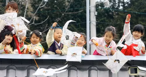 Các em bé thành phố Busan, Hàn Quốc thả diều trên một cây cầu trước khi bước sang năm mới. Ảnh: Chosun