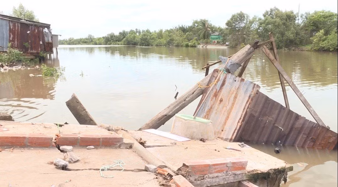 Một phần nhà bị sạt lở xuống sông.