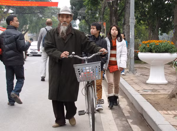 Một cụ già dắt xe dạo phố hoa