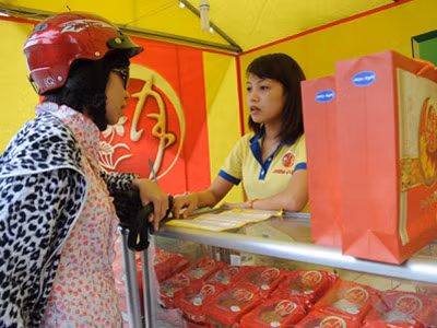 Khách hàng tìm hiểu sản phẩm tại một quầy bán bánh trung thu trên phố Giảng Võ, Hà Nội. Khách hàng tìm hiểu sản phẩm tại một quầy bán bánh trung thu trên phố Giảng Võ, Hà Nội