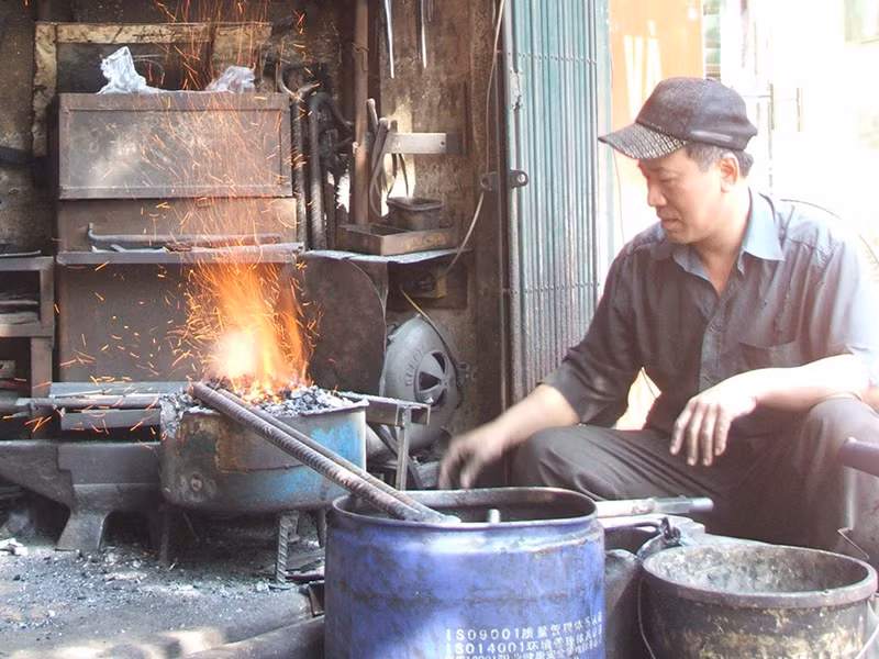 Ông Nguyễn Phương Hùng bên bễ lò rèn đỏ lửa. Ông Nguyễn Phương Hùng bên bễ lò rèn đỏ lửa