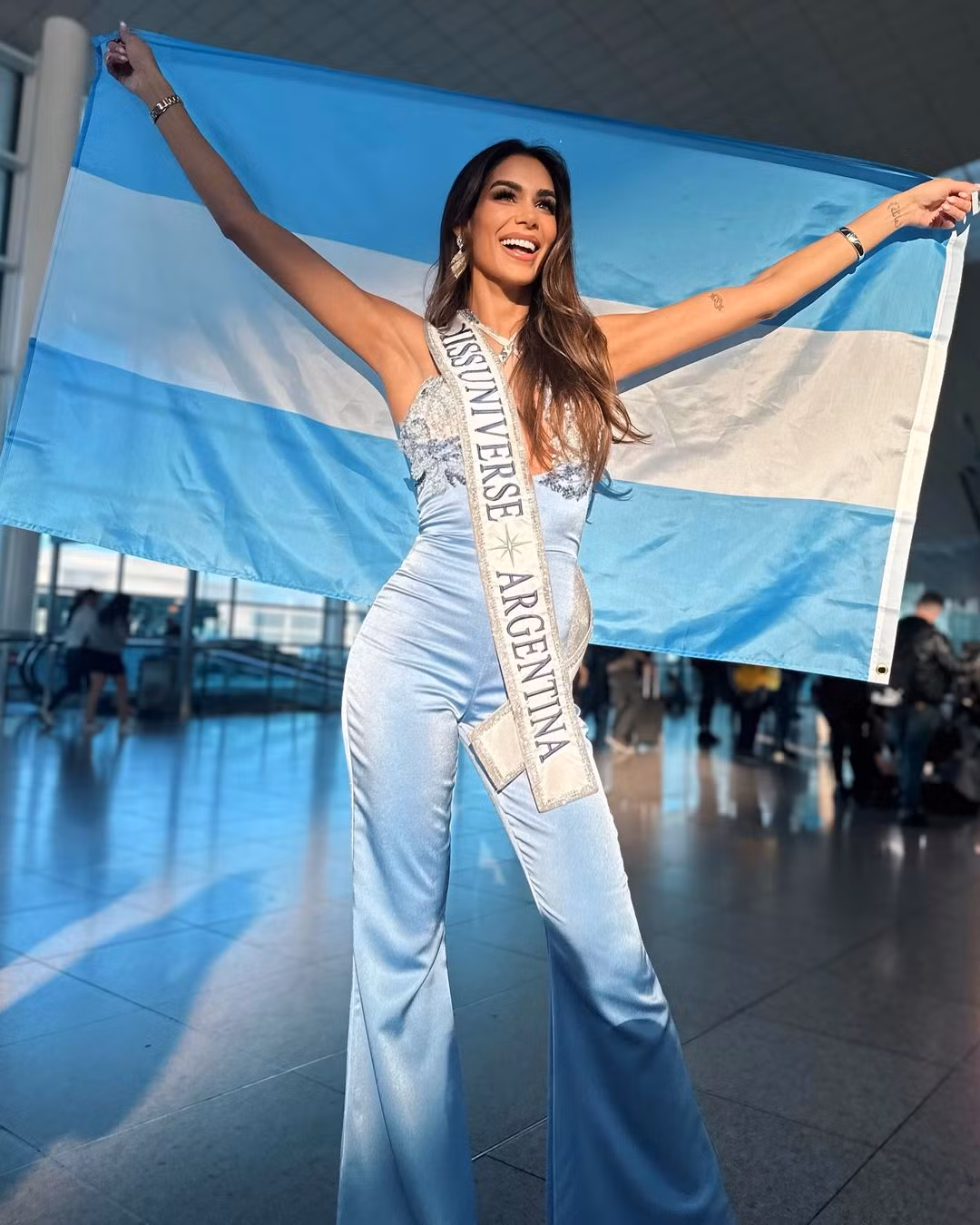 Đại diện Argentina diện jumpsuit màu xanh nổi bật ở sân bay.