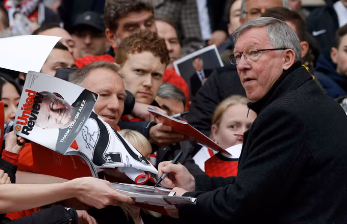 HLV Ferguson ký tặng người hâm mộ - Ảnh: Reuters