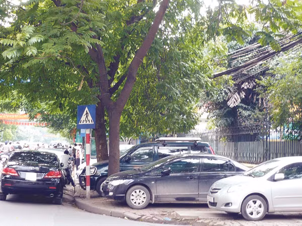 Theo Luật Giao thông đường bộ, vỉa hè chỉ dành cho người đi bộ nhưng tại Hà Nội, vỉa hè đang được cấp phép để ô tô. Ảnh: Trọng Đảng