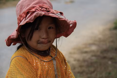 Bé gái co người vì lạnh khi đi chăn bò trên vùng núi cao thuộc xã Lũng Cú. Ảnh: Trường Phong. 
