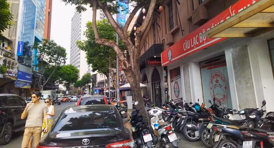 Du khách nước ngoài phải đi bộ xuống lòng đường để ra phố đi bộ Nguyễn Huệ, tiềm ẩn nhiều nguy cơ mất an toàn nhưng không còn lối đi nào khác.