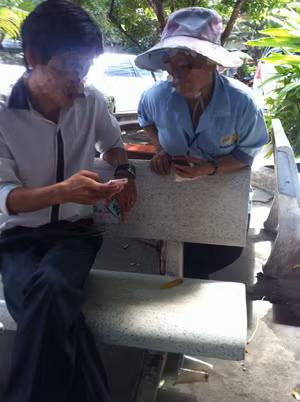 Bà M. đang giới thiệu với một người cần xin con ngay trong khuôn viên Bệnh viện Từ Dũ Ảnh: L.N