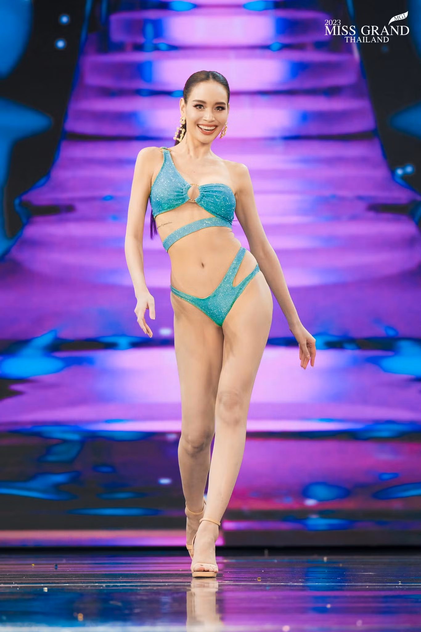 Người đẹp Pimjira Charoenlak - Miss Grand Bangkok khoe hình thể và đôi chân dài trong phần thi bikini. Năm 2014, cô từng tham gia bộ phim về đề tài thi sắc đẹp có tên Cuộc chiến sắc đẹp (Songkram Nang Ngarm). Đây là một trong những bộ phim nổi tiếng khai thác những câu chuyện hậu trường ở các cuộc thi sắc đẹp và cũng được một bộ phận khán giả Việt Nam biết đến.