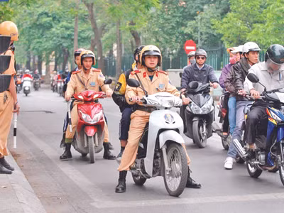 Một số CSGT lấy xe đưa các em đến trường cho kịp giờ học. Ảnh: Xuân Phú