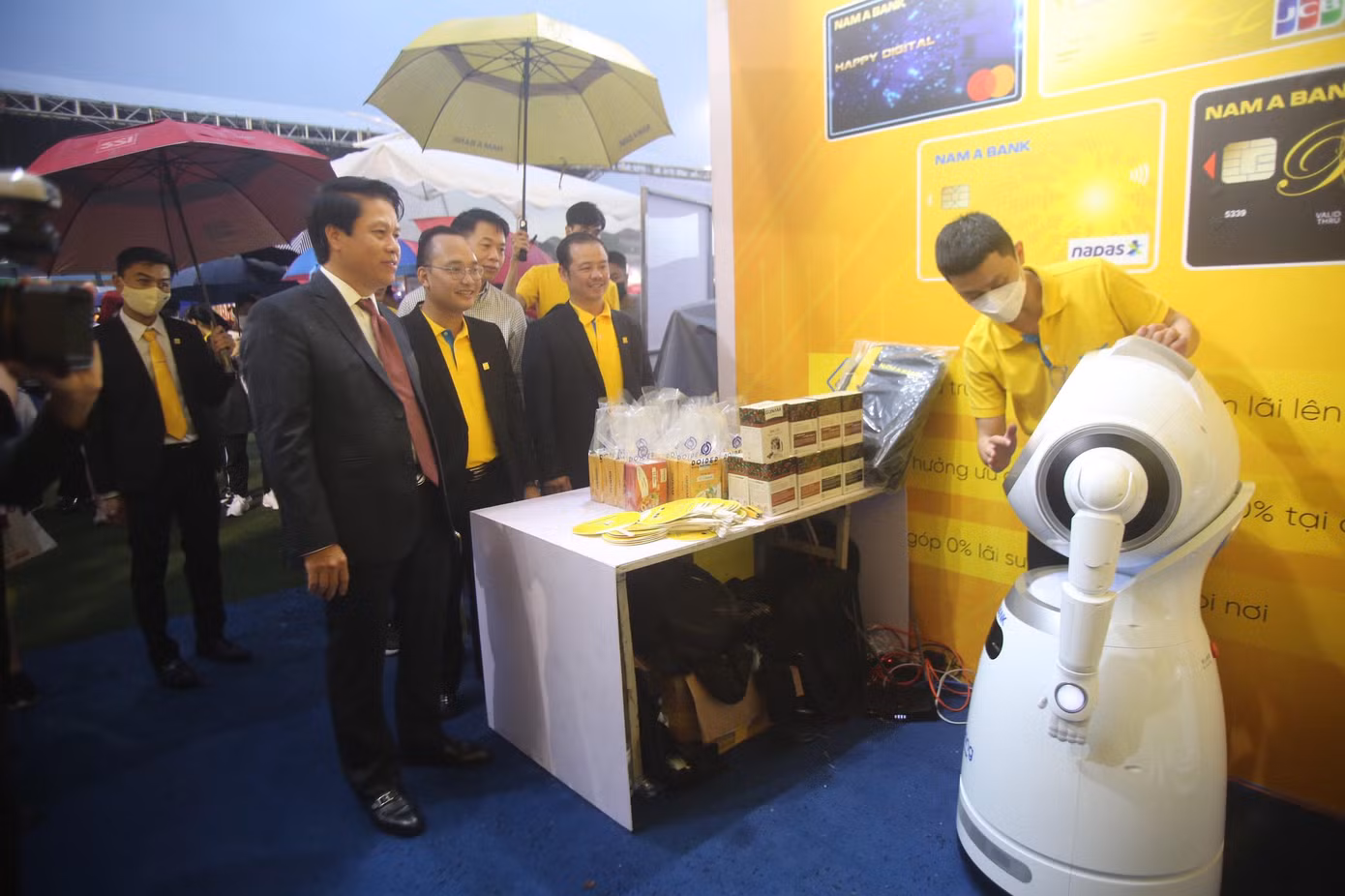 Gian hàng của Nam Á Bank ấn tượng khi mang đến trải nghiệm robot. Chia sẻ với Phó Thống đốc, đại diện Nam Á Bank cho biết, bên cạnh đẩy mạnh chuyển đổi số, đáp ứng nhu cầu đa dạng của khách hàng trong giao dịch, Nam Á Bank còn hướng đến hình thành hệ sinh thái thông minh, thiết lập việc kết nối dịch vụ ngân hàng số với các dịch vụ số khác mang lại trải nghiệm liền mạch, trên mọi lĩnh vực cho người dùng. Trong đó, hệ sinh thái số Onebank – "Một chạm mọi trải nghiệm", đánh dấu bước chuyển mình mới trong hành trình chinh phục công nghệ 4.0 của Nam A Bank. Nhờ Onebank, khách hàng đã hình thành thói quen sử dụng các dịch vụ mà không cần trực tiếp đến ngân hàng. Gian hàng của Nam Á Bank ấn tượng khi mang đến trải nghiệm robot. Chia sẻ với Phó Thống đốc, đại diện Nam Á Bank cho biết, bên cạnh đẩy mạnh chuyển đổi số, đáp ứng nhu cầu đa dạng của khách hàng trong giao dịch, Nam Á Bank còn hướng đến hình thành hệ sinh thái thông minh, thiết lập việc kết nối dịch vụ ngân hàng số với các dịch vụ số khác mang lại trải nghiệm liền mạch, trên mọi lĩnh vực cho người dùng. Trong đó, hệ sinh thái số Onebank – "Một chạm mọi trải nghiệm", đánh dấu bước chuyển mình mới trong hành trình chinh phục công nghệ 4.0 của Nam A Bank. Nhờ Onebank, khách hàng đã hình thành thói quen sử dụng các dịch vụ mà không cần trực tiếp đến ngân hàng.
