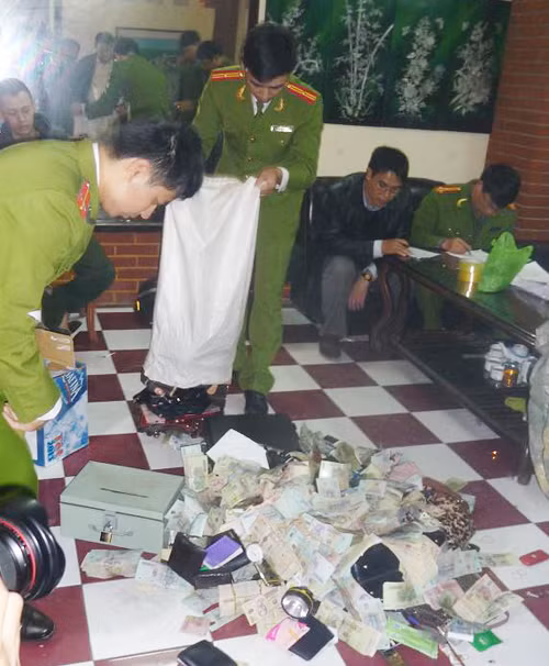 Những cô gái có mặt trong xới bạc. Các con bạc bị bắt. Cảnh sát kiểm tra số tiền.