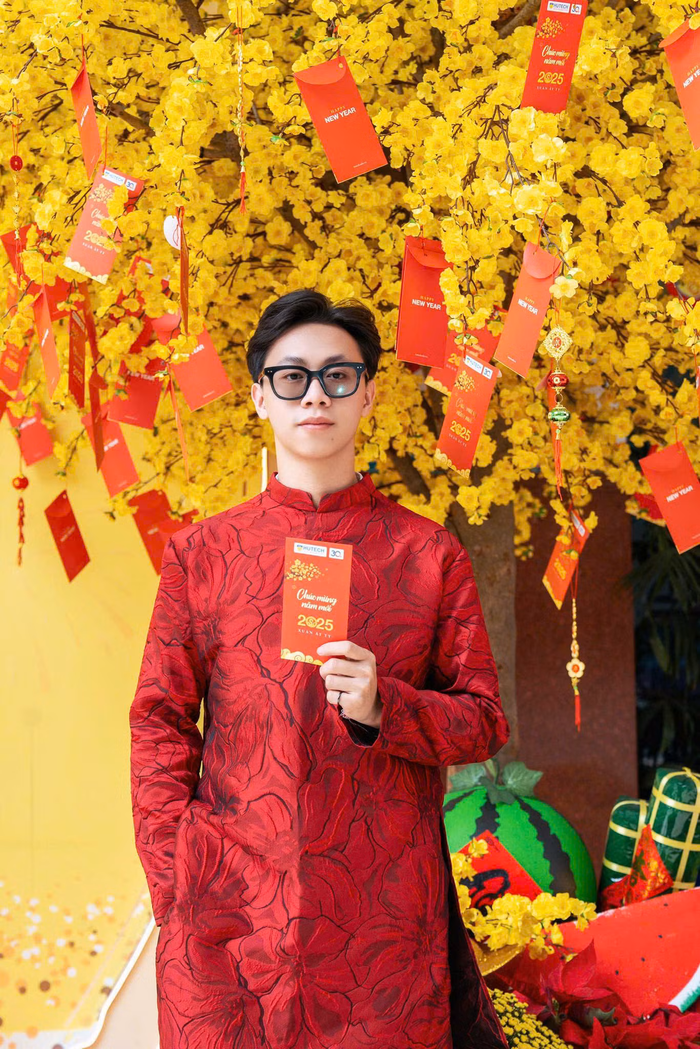 Anh Huy (24 tuổi) với chiếc áo dài đỏ, tự tin có cho mình một bộ ảnh Tết trước không gian chụp ảnh đầu tư kỹ lưỡng của trường.