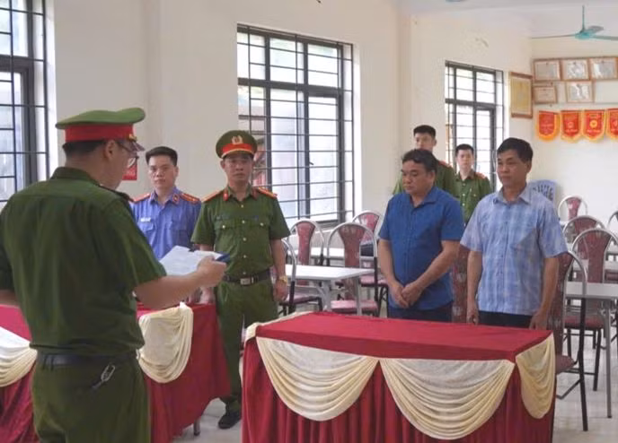 Thi hành quyết định khởi tố đối với 2 bị can Hà Văn Quý (áo kẻ) và Hoàng Văn Duẩn (áo xanh).