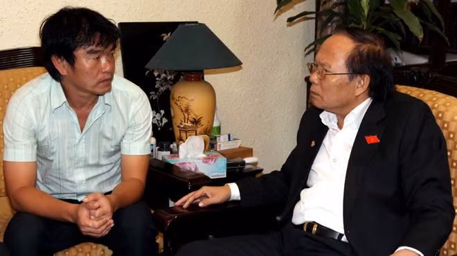 HLV Phan Thanh Hùng (trái) báo cáo Bộ trưởng Bộ VH-TT&DL Hoàng Tuấn Anh về tình hình đội tuyển trước giờ dự AFF Cup 2012 trưa 19-11