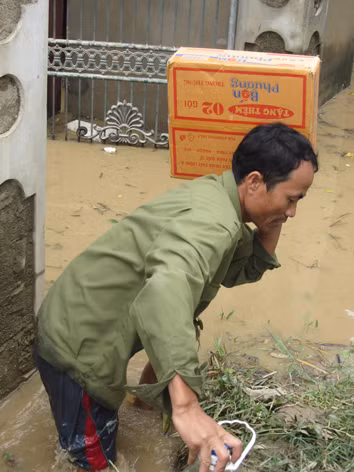 Một người dân với thùng mì tôm cứu trợ. Ảnh: Q.L