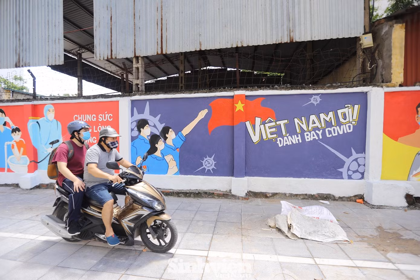 Những khẩu hiệu " Việt Nam ơi! Đánh bay COVID" được vẽ lên tường cùng với hình ảnh các bác sĩ tuyến đầu phòng dịch.