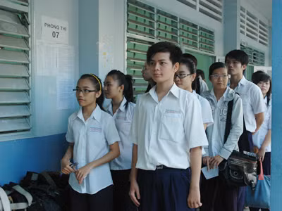 Thí sinh xếp hàng đợi giám thị gọi vào phòng thi làm bài môn Ngữ văn sáng nay. Ảnh: Quang Phương