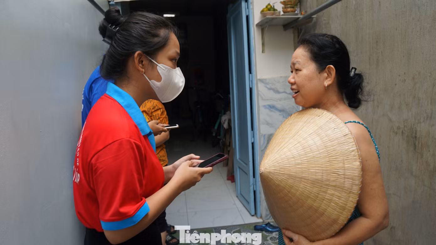 Chiến sĩ tình nguyện trường đại học Đồng Tháp "gõ cửa từng nhà" hỗ trợ người dân cài đặt ứng dụng VNeID tại TP Sa Đéc. Ảnh: Hòa Hội