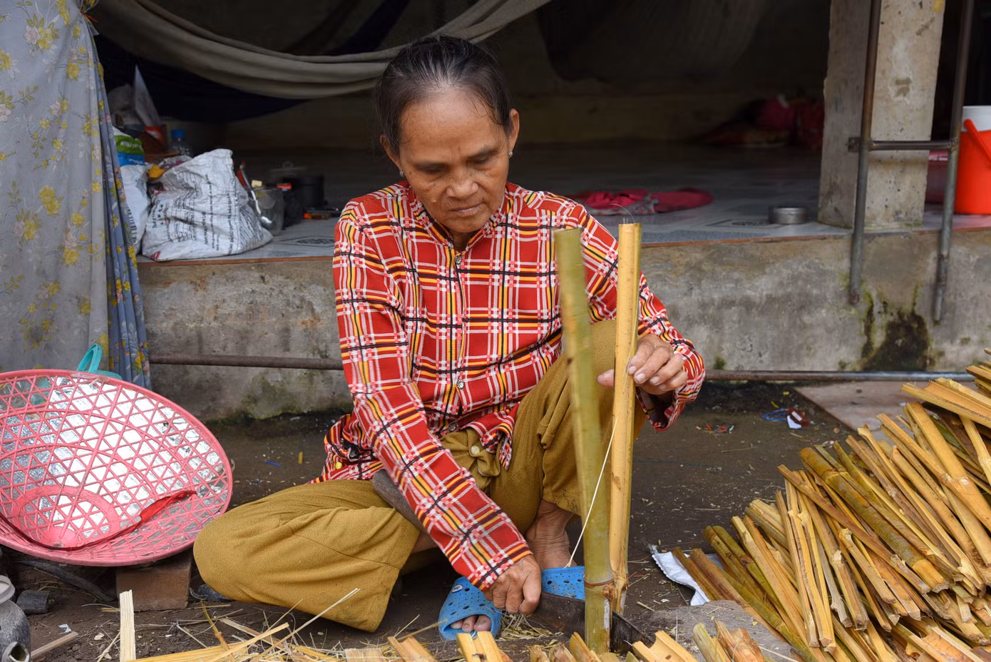 Vợ ông Đỉnh phụ chẻ tre làm lọp. Ảnh: Hòa Hội. Vợ ông Đỉnh phụ chẻ tre làm lọp. Ảnh: Hòa Hội.