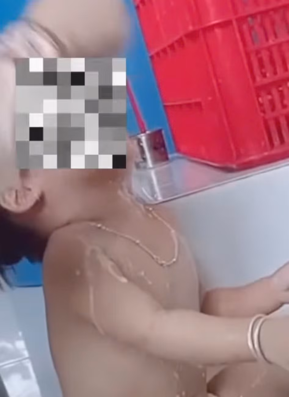 Nhân viên nấu ăn nhồi nhét thức ăn vào miệng trẻ em. Ảnh cắt từ clip.