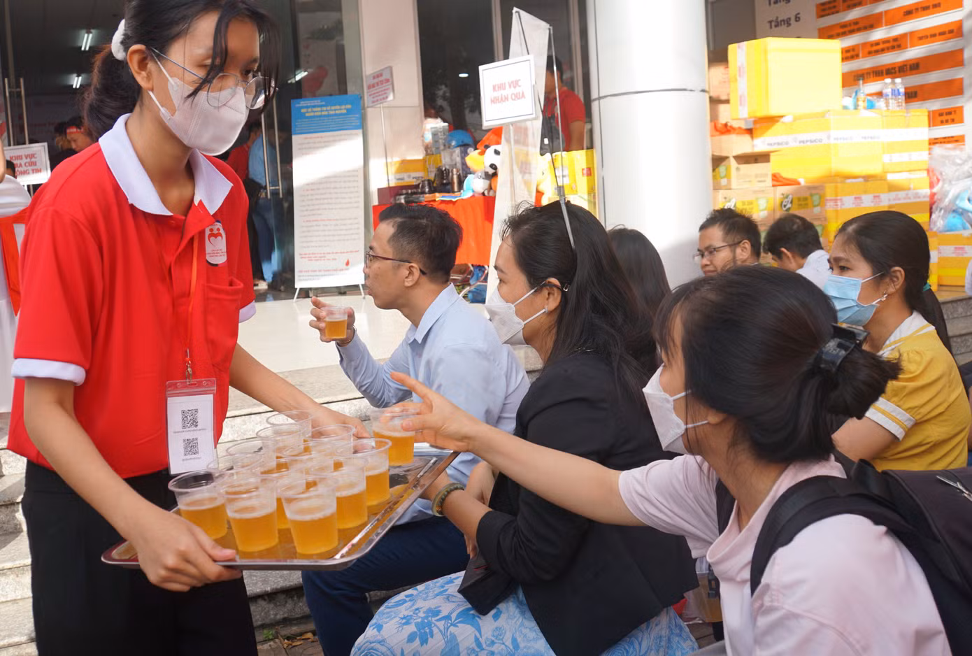 Tình nguyện viên hỗ trợ nước uống cho người tham gia hiến máu.