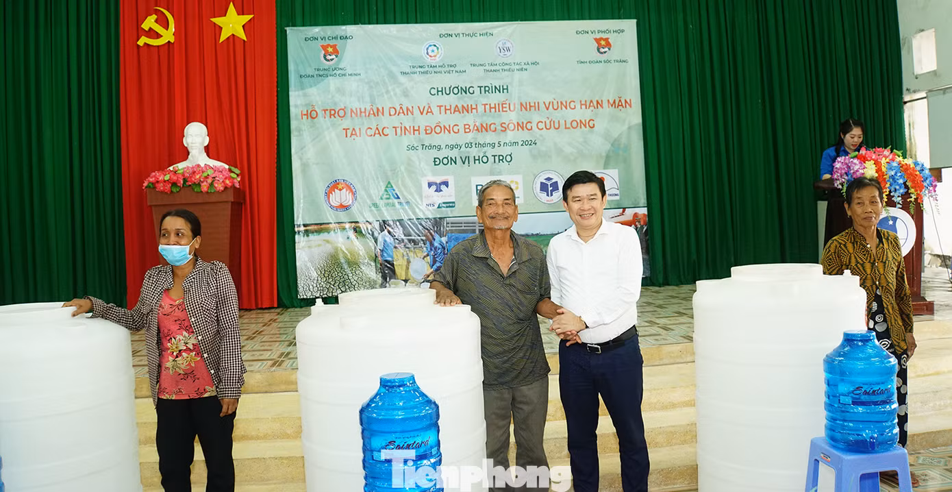 Anh Cái Quang Bình - Giám đốc Trung tâm Hỗ trợ Thanh Thiếu nhi Việt Nam trao tặng bồn nước và nước ngọt cho bà con tại xã Long Phú. Ảnh: Hòa Hội