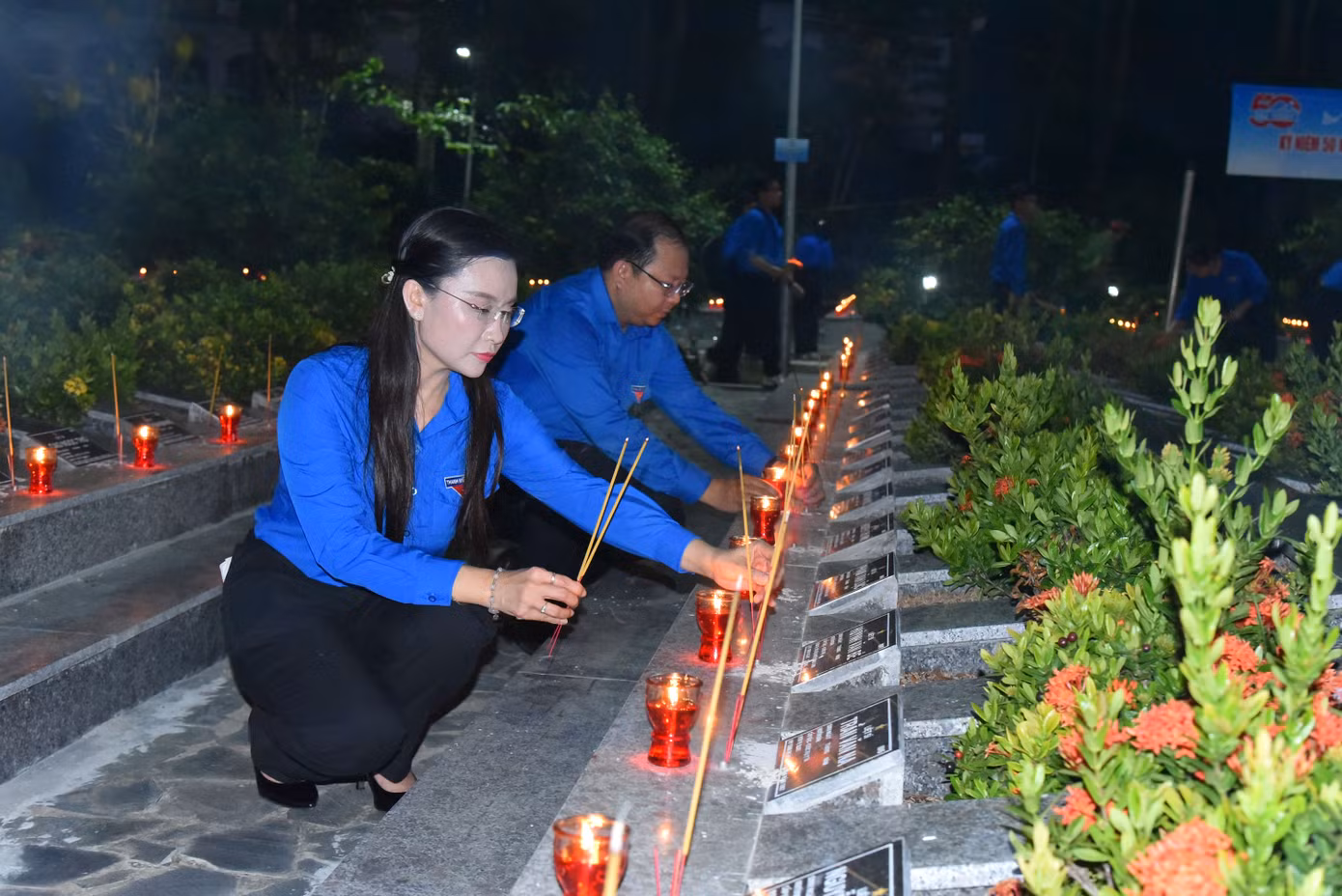 Chị Nguyễn Phạm Duy Trang thắp nhang tại các phần mộ anh hùng liệt sĩ. Ảnh: Hòa Hội