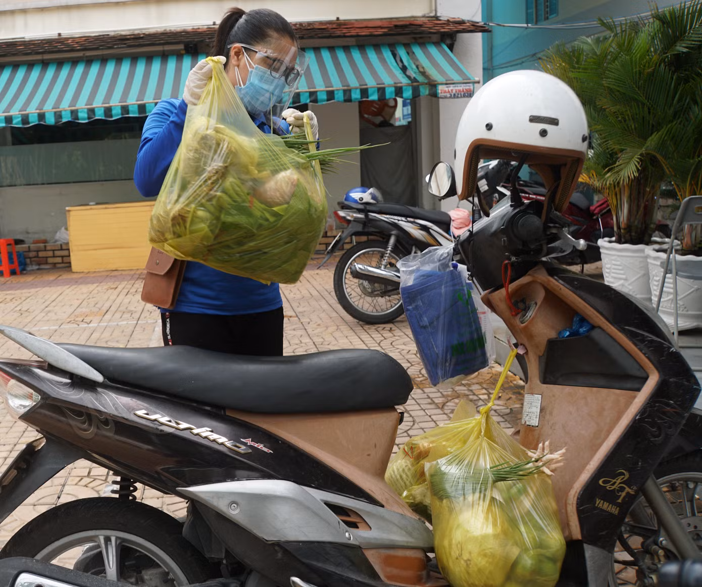 Cô Trần Thị Mỹ Duyên chuẩn bị giao thực phẩm cho người dân. - Ảnh: Hòa Hội