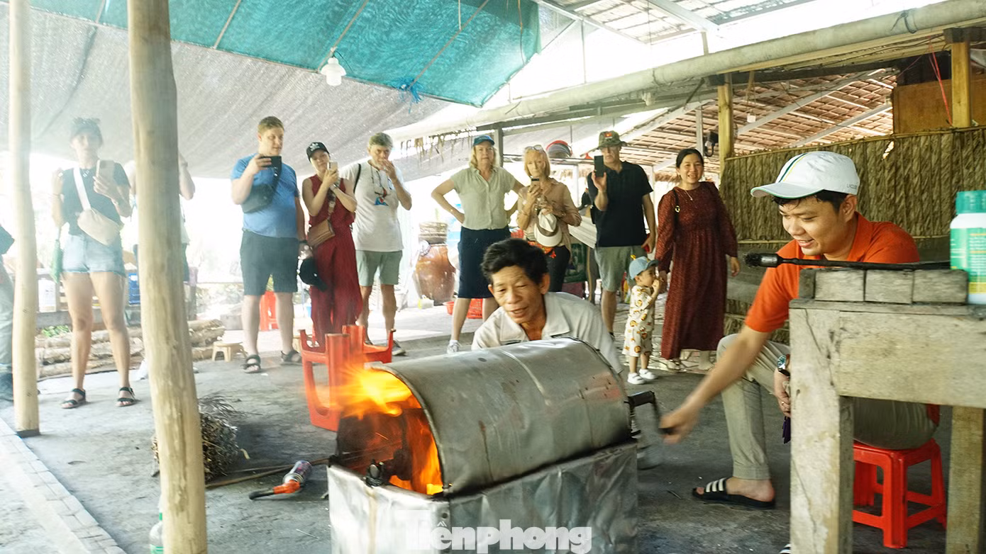 Khách trải nghiệm nổ cốm gạo tại nhà bà Bảy Muôn. Ảnh: Hòa Hội Khách trải nghiệm nổ cốm gạo tại nhà bà Bảy Muôn. Ảnh: Hòa Hội