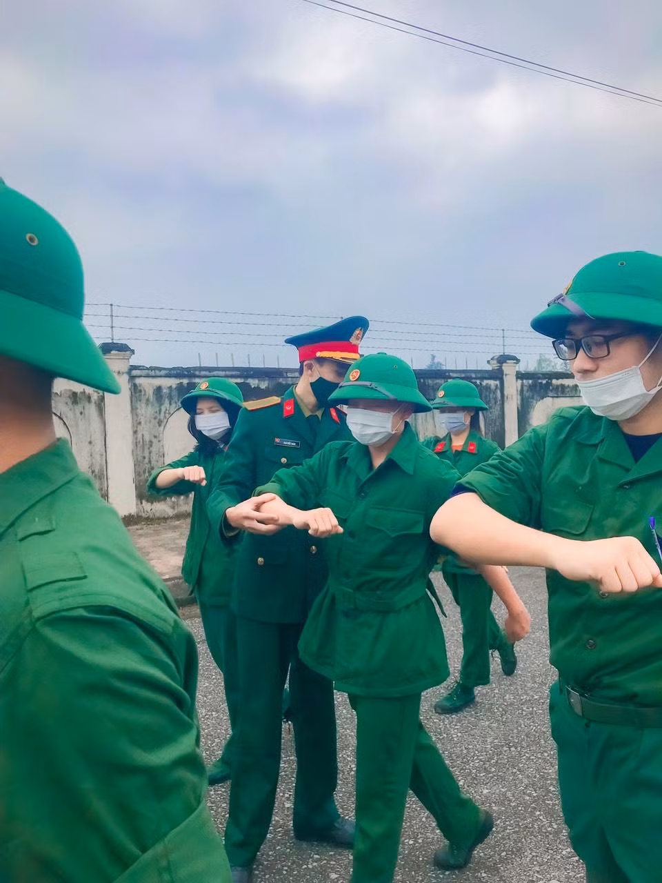 Hỗ trợ giảng viên hướng dẫn sinh viên học quân sự.