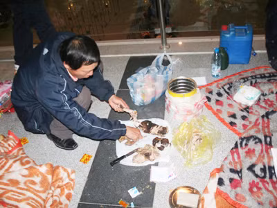 Lao động Việt Nam đang luộc thịt chó ăn với mỳ tôm ngay tại sân bay Ảnh: Đình Thắng