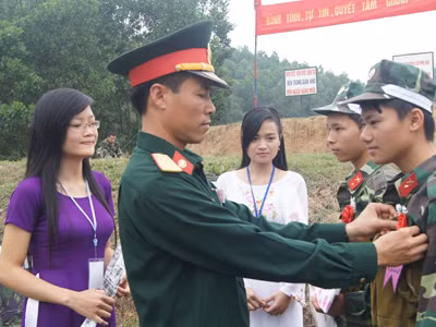 Thiếu tá Nguyễn Mạnh Cường - Phó Tham mưu trưởng Trung đoàn Thông tin 601 gắn Hoa bắn giỏi cho hai chiến sĩ Dương Đình Nam (77 điểm) và Vi Văn Tiến (79 điểm)
