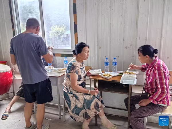 Những người dân bị ảnh hưởng bởi mưa do bão đang ăn cơm ở nhà tạm tại tỉnh Liêu Ninh (Trung Quốc) vào ngày 27/7. Ảnh: Xinhua. Những người dân bị ảnh hưởng bởi mưa do bão đang ăn cơm ở nhà tạm tại tỉnh Liêu Ninh (Trung Quốc) vào ngày 27/7. Ảnh: Xinhua.