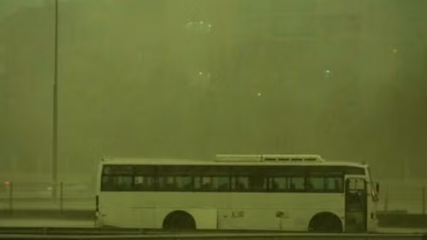 Một chiếc xe bus đứng dưới mưa khi bầu trời biến thành màu xanh lá cây ở Dubai. Ảnh: Hindustan Times.