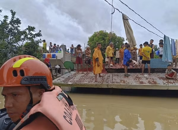 Người dân đứng trên mái nhà để tránh nước lụt do bão Trami (ở Philippines gọi là bão Kristine) tại tỉnh Albay (Philippines) vào hôm nay, 23/10. Ảnh: Lực lượng phòng vệ biển Philippines/ AP.