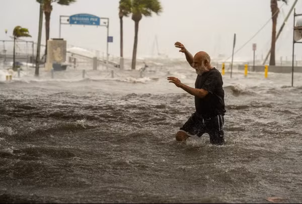 Một người dân lội ở khu vực ngập lụt do bão Helene tại Florida (Mỹ). Ảnh: Thomas Simonetti for The Washington Post via Getty Images. Một người dân lội ở khu vực ngập lụt do bão Helene tại Florida (Mỹ). Ảnh: Thomas Simonetti for The Washington Post via Getty Images.