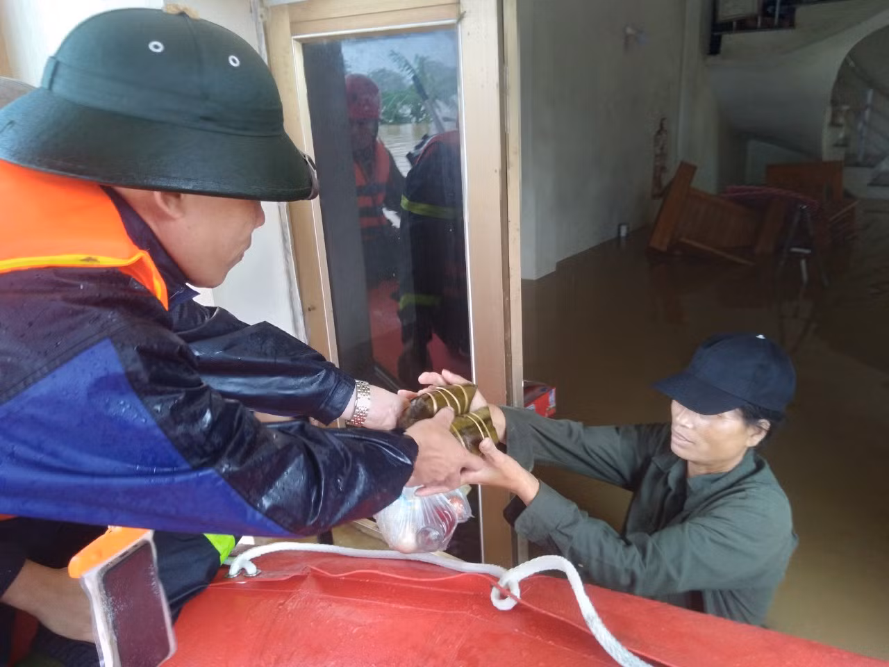 Lực lượng cứu hộ phát thức ăn sáng cho người dân. Ảnh: Nguyễn Thắng