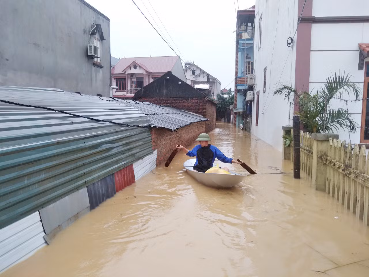 Người dân bơi thuyền ra nhận lương thực, thực phẩm. Ảnh: Nguyễn Thắng