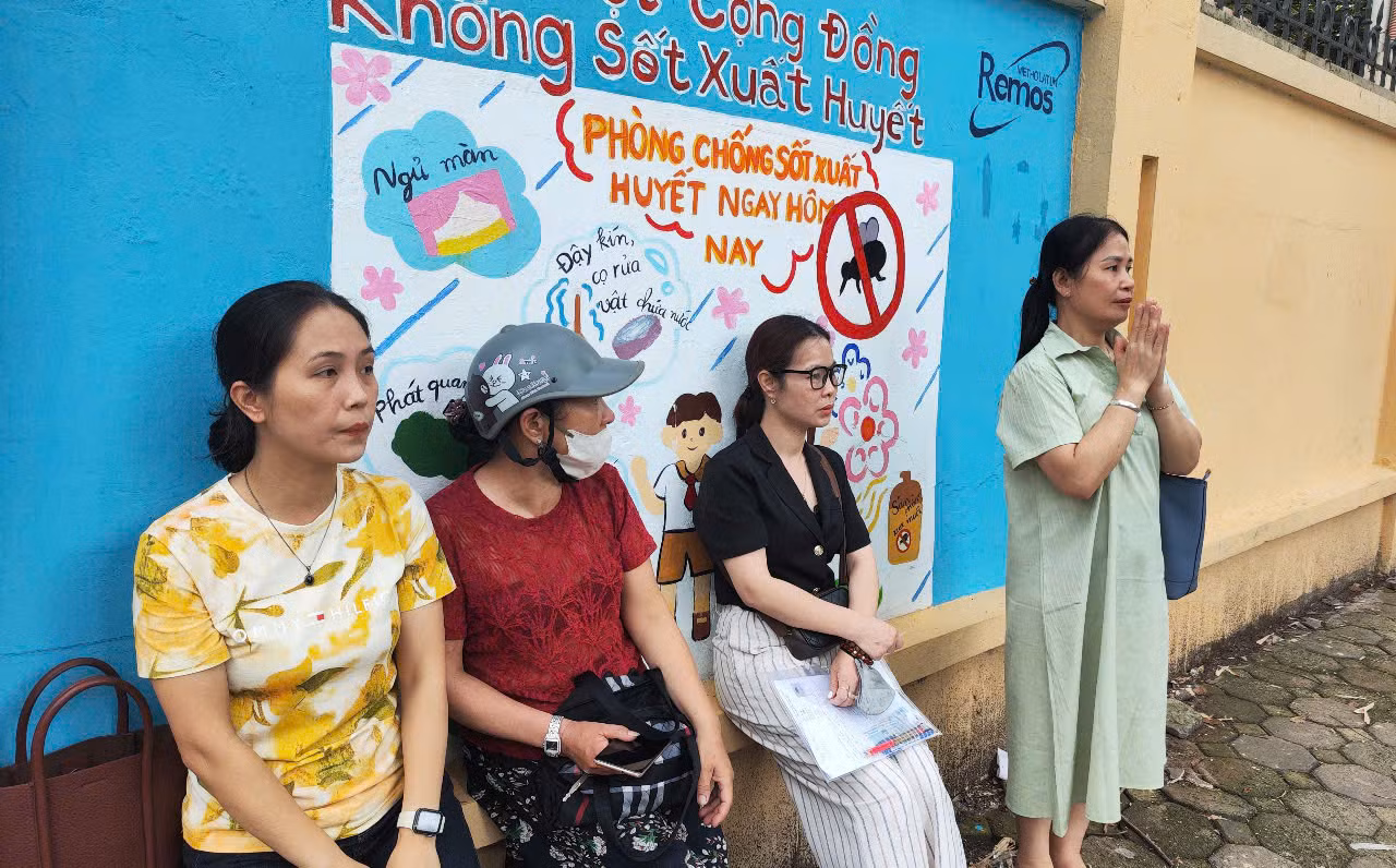 Chị Huyền và chị Hoa cùng các phụ huynh khác chờ con ngoài điểm thi. Ảnh: Thúy Hằng.